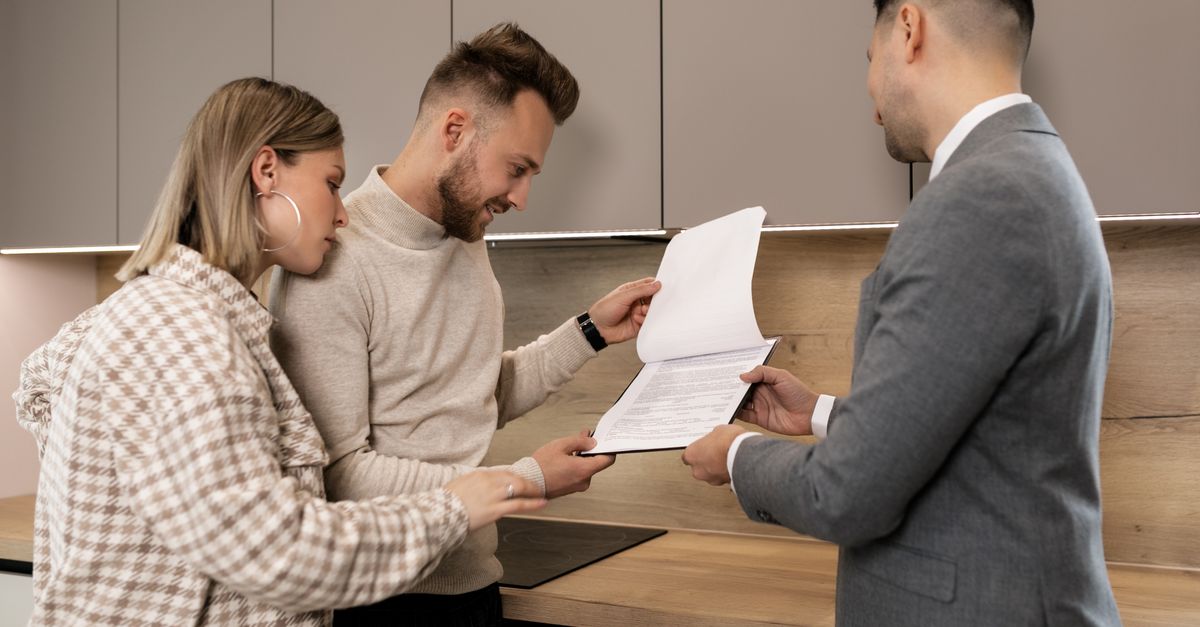 Hai bên cùng xem mẫu hợp đồng đặt cọc nhà đất với tư vấn viên trước khi ký